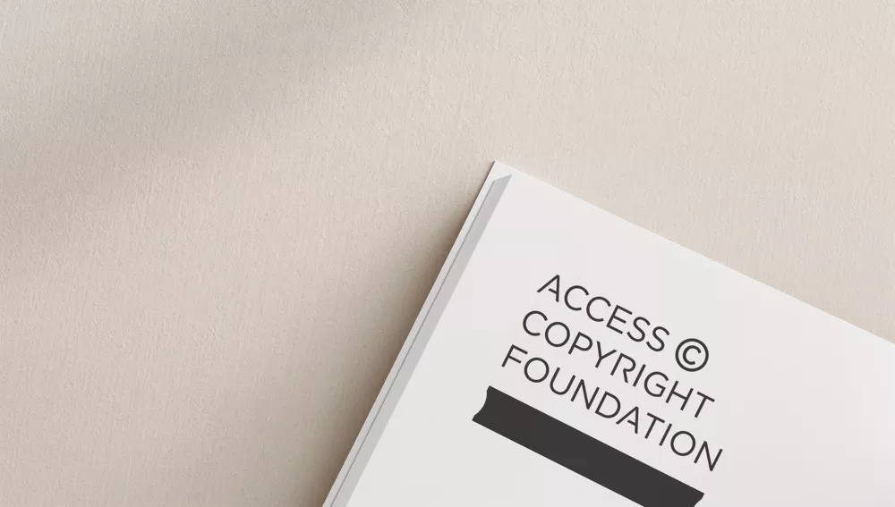 Partial view of a white book on a beige surface, displaying the text "Access Copyright Foundation" in bold black letters.
